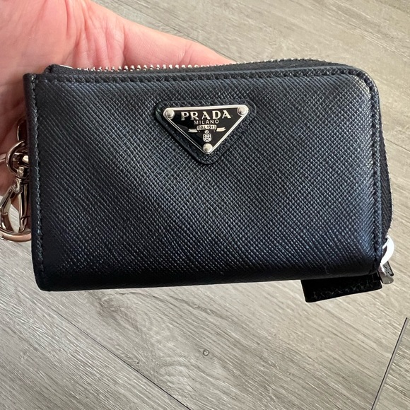 snap-hook and ring
Zipper closure
Enameled metal triangle logo
Two card slots - Picture 8 of 11